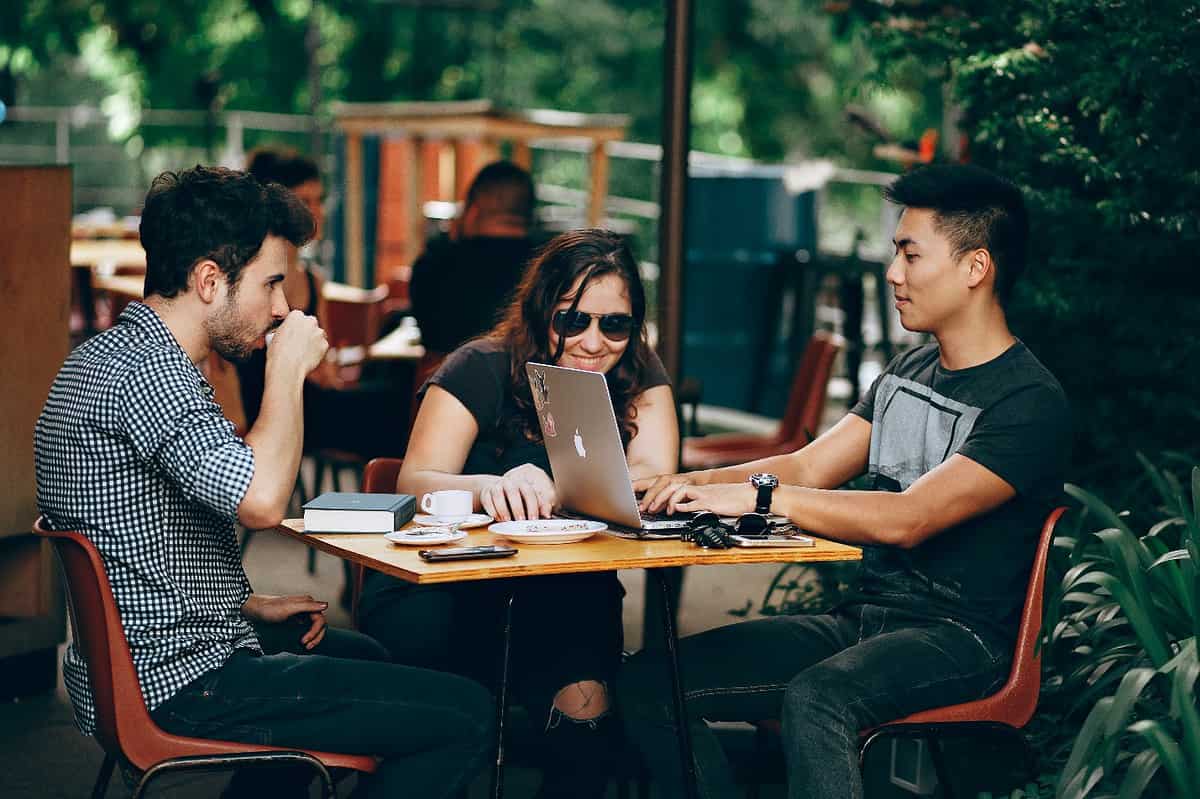 A Group Of People Sitting At A Table Outside Description Automatically Generated With Medium Confidence