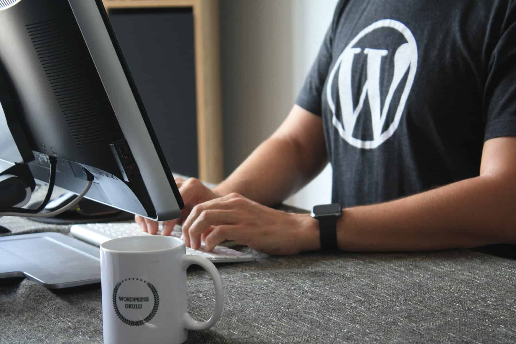 Person In Black And White T-Shirt Using Computer