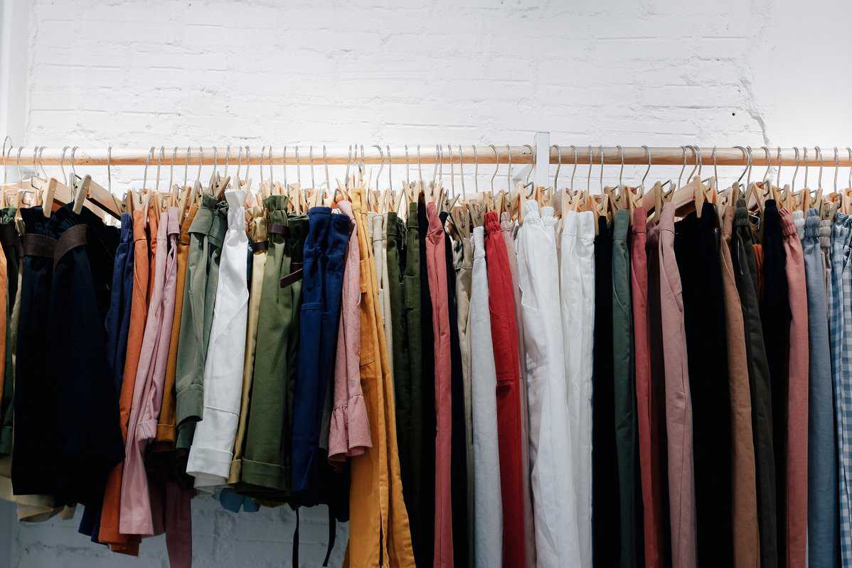 Assorted-Color Clothes Lot Hanging On Wooden Wall Rack