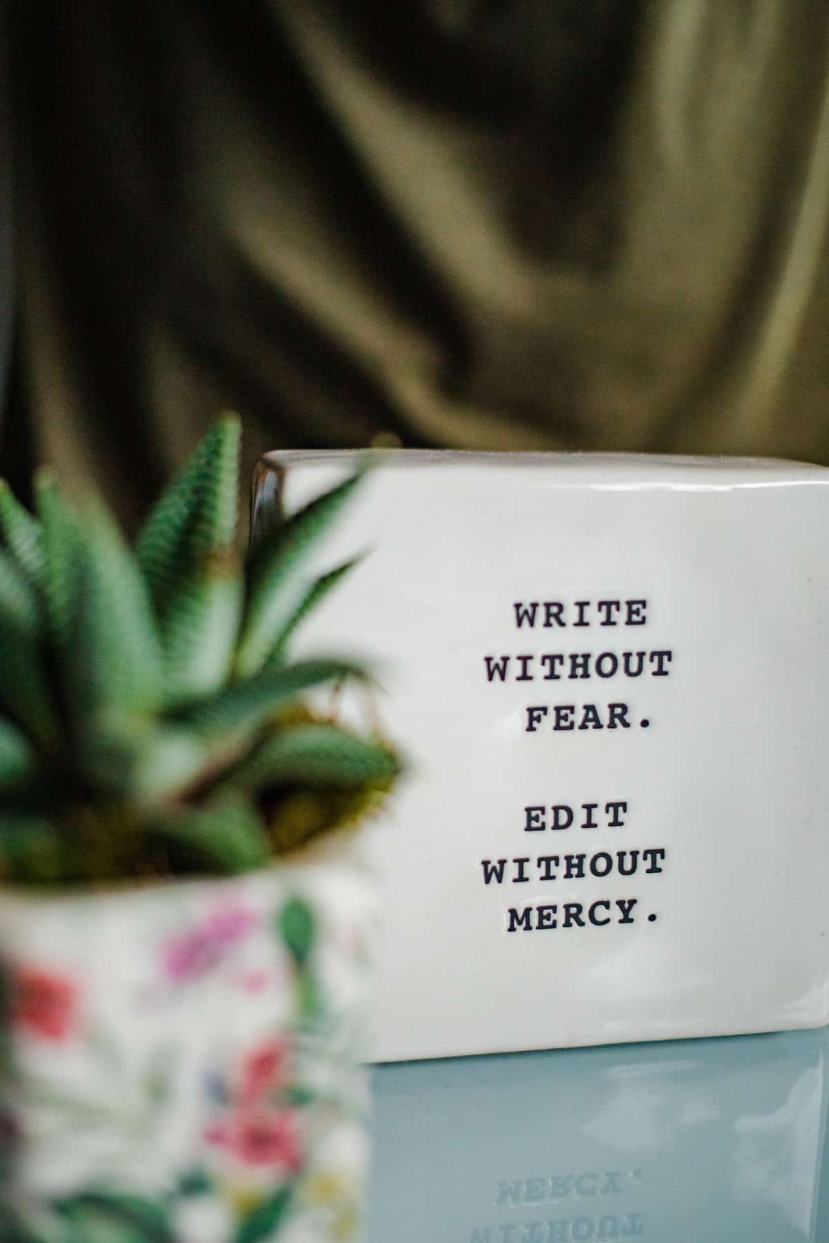 A White Box With Writing On It Next To A Plant