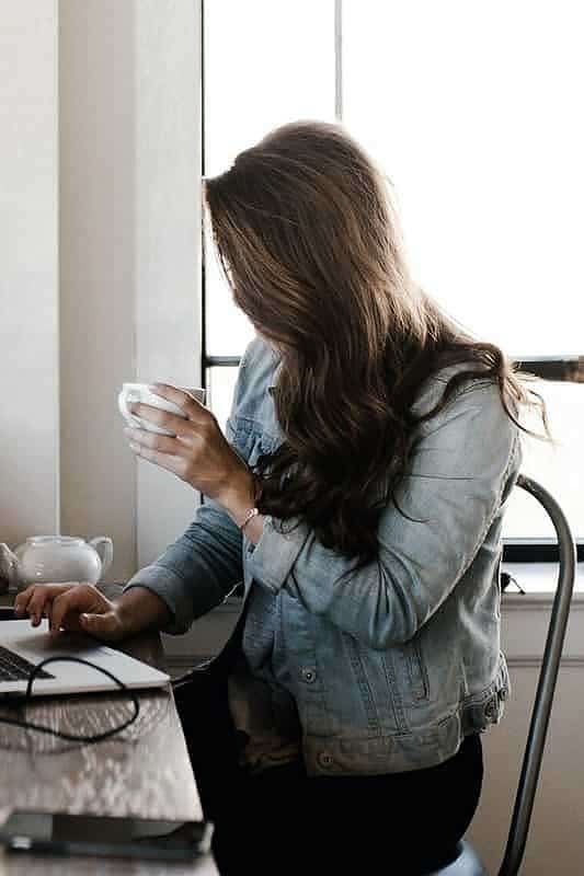 Free Woman in Gray Jacket Sitting Beside Desk Stock Photo